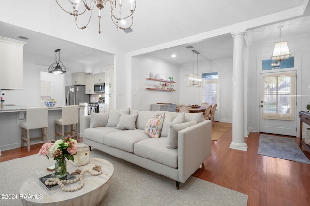 living room with ornate columns, crown molding, and hardwood / wood-style flooring