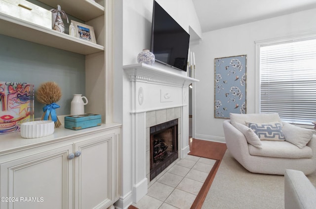 living room featuring light carpet and a tiled fireplace