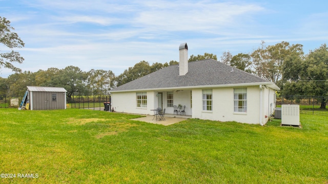 back of property featuring a patio area, a yard, central AC, and a storage shed