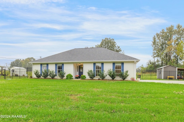 ranch-style home with a storage shed and a front lawn