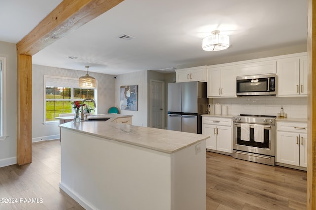 kitchen featuring sink, stainless steel appliances, light stone counters, light hardwood / wood-style flooring, and white cabinets