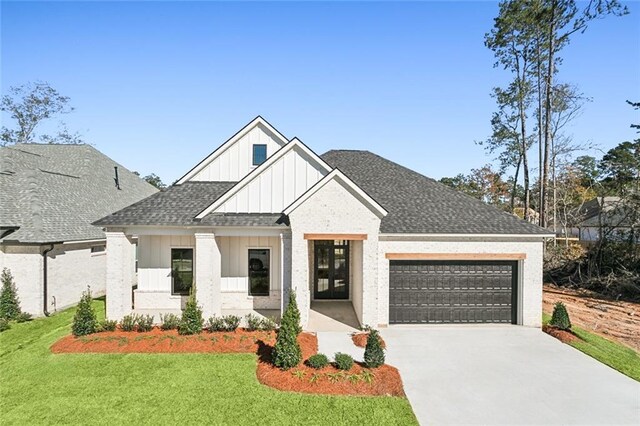 modern farmhouse with an attached garage, a shingled roof, concrete driveway, a front lawn, and board and batten siding