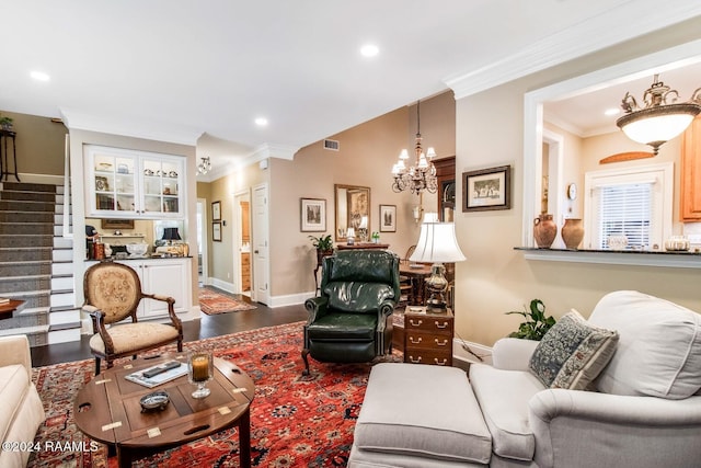 living room featuring crown molding, wood-type flooring, and an inviting chandelier