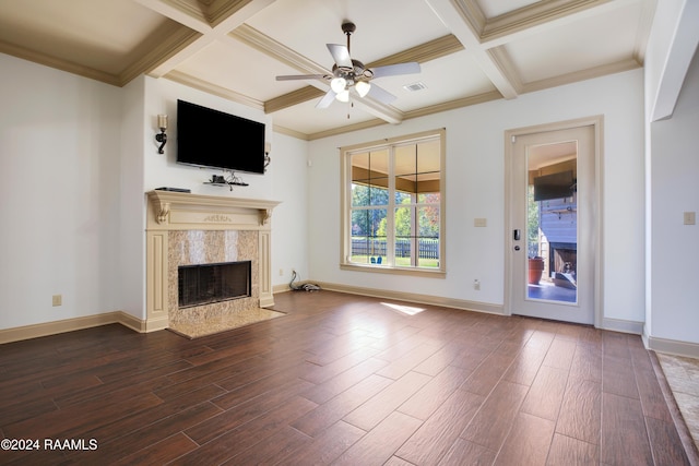 unfurnished living room with beam ceiling, ceiling fan, coffered ceiling, dark hardwood / wood-style flooring, and a fireplace