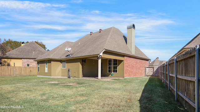 rear view of house with a lawn and a patio area