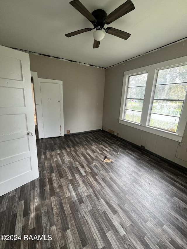 unfurnished room featuring ceiling fan and dark wood-type flooring