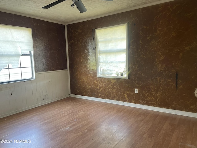 spare room with hardwood / wood-style floors, ornamental molding, and ceiling fan