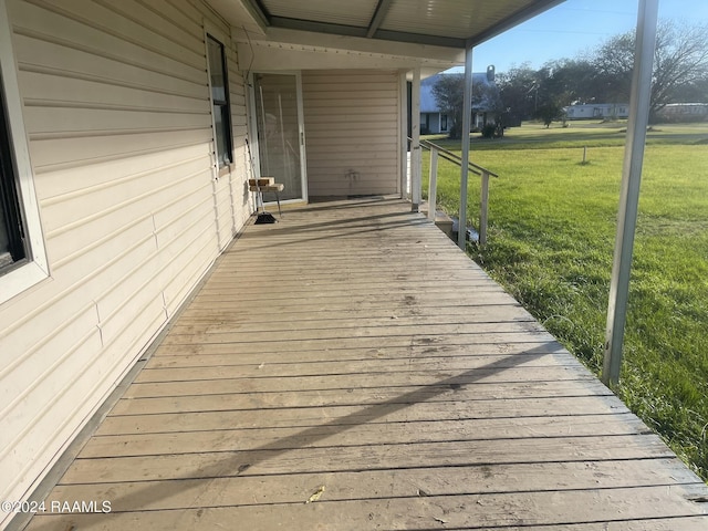 wooden deck featuring a lawn