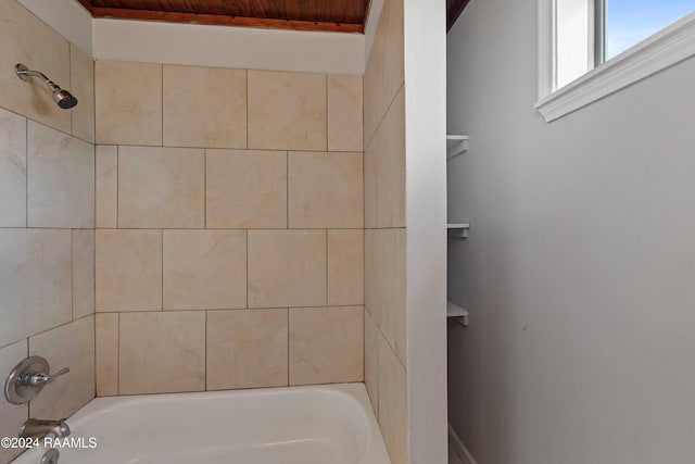 bathroom with tiled shower / bath combo and wooden ceiling