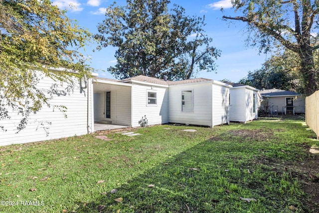 rear view of property featuring a lawn