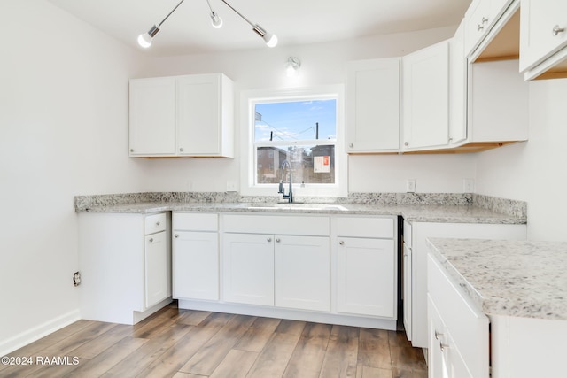 kitchen with white cabinetry, sink, and light hardwood / wood-style floors