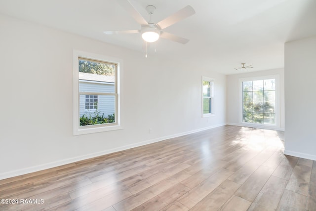 empty room with ceiling fan and light hardwood / wood-style floors