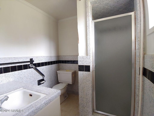 bathroom with toilet, a shower with door, vanity, tile walls, and ornamental molding