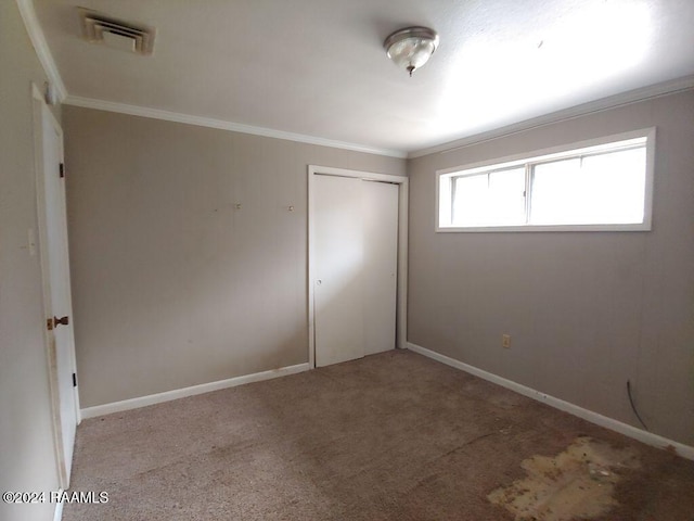 unfurnished bedroom with light carpet, a closet, and ornamental molding