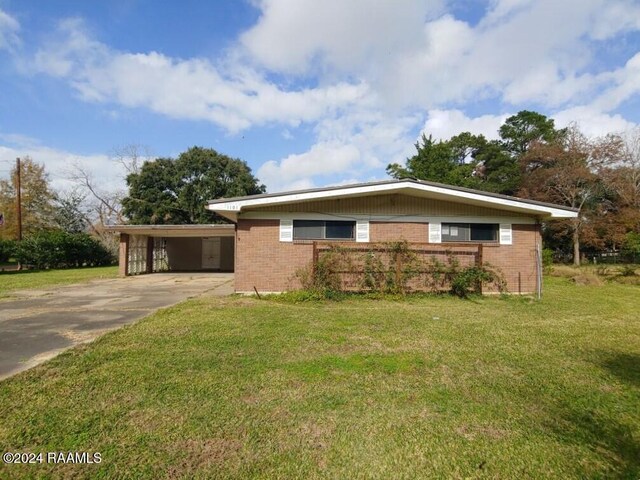 ranch-style home featuring a carport and a front yard