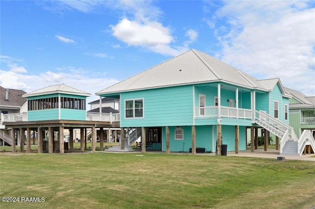 back of house with a lawn and a sunroom