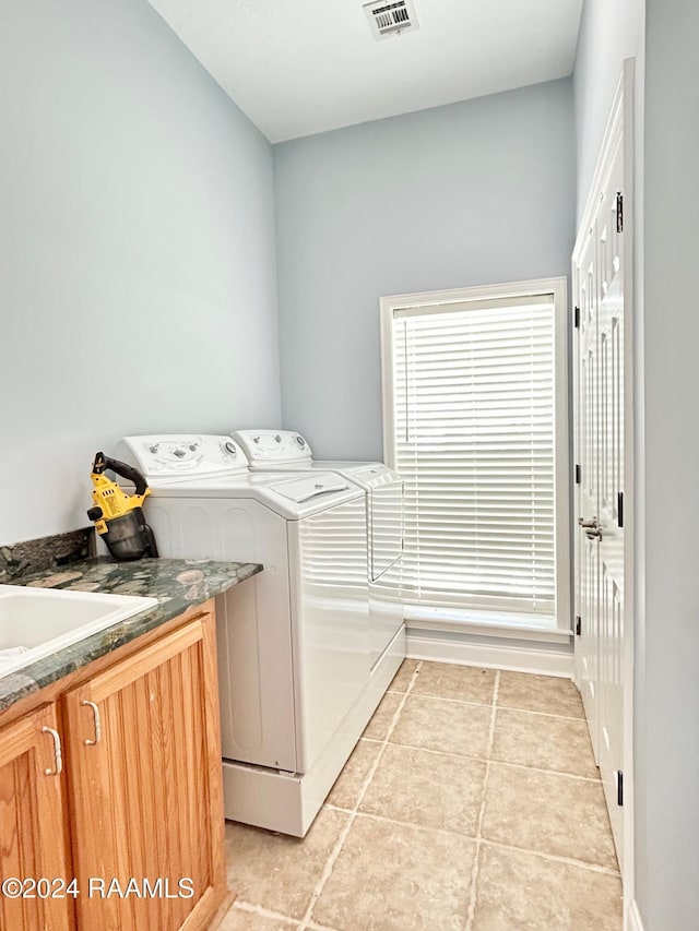 washroom featuring washer and dryer, light tile patterned flooring, cabinets, and sink