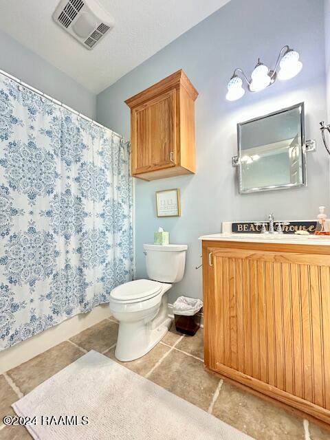 bathroom featuring tile patterned floors, vanity, and toilet