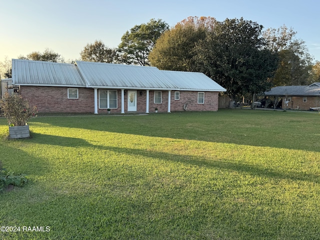 ranch-style home with a lawn