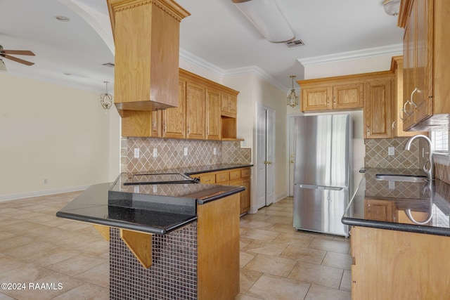 kitchen featuring kitchen peninsula, stainless steel fridge, pendant lighting, a kitchen bar, and decorative backsplash