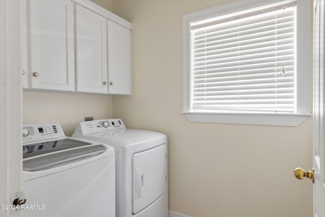 washroom featuring washer and dryer and cabinets