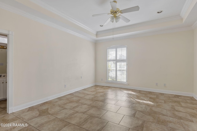 spare room with ceiling fan, a raised ceiling, and crown molding