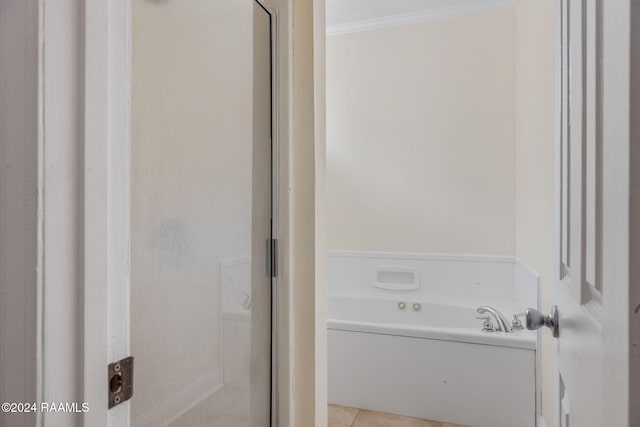 bathroom with tile patterned flooring, a bathtub, and ornamental molding