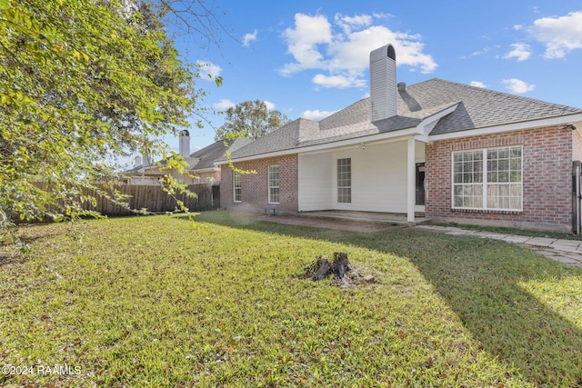 rear view of property featuring a yard and a patio