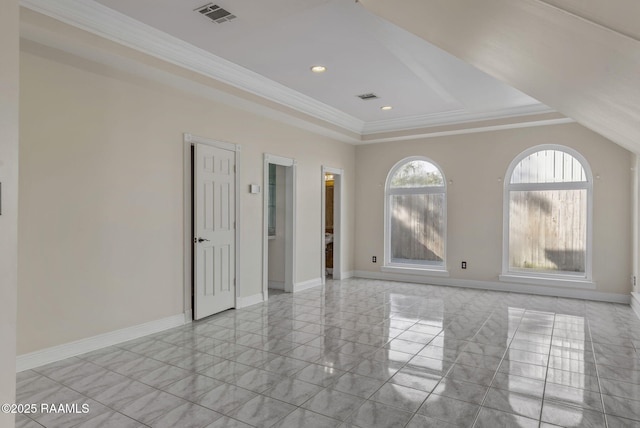 spare room with ornamental molding and a raised ceiling