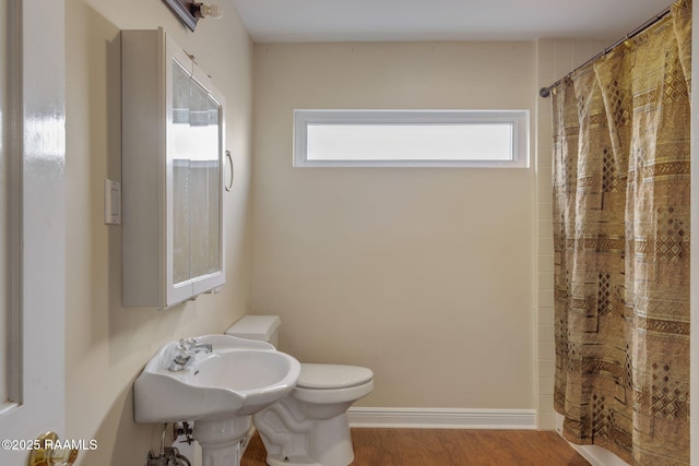 bathroom with toilet, a wealth of natural light, hardwood / wood-style flooring, and curtained shower