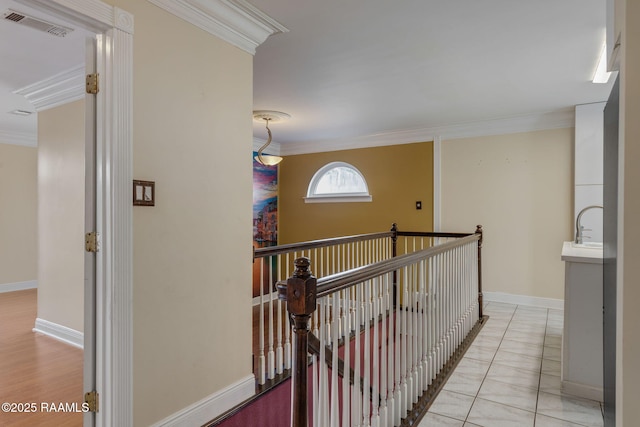 hallway featuring light tile patterned flooring and ornamental molding