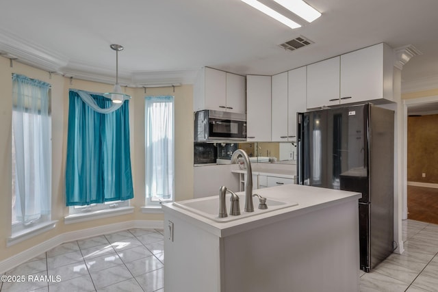 kitchen featuring sink, white cabinetry, hanging light fixtures, an island with sink, and black refrigerator