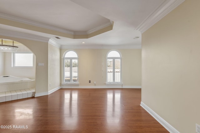 unfurnished room featuring hardwood / wood-style flooring, an inviting chandelier, crown molding, and a raised ceiling