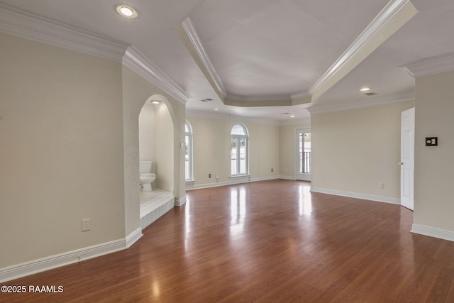 unfurnished living room featuring crown molding, a tray ceiling, and hardwood / wood-style flooring