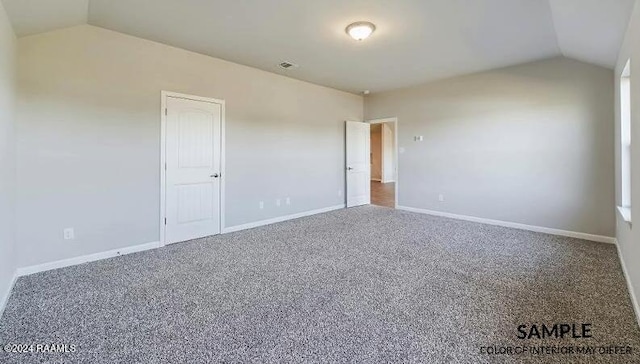 carpeted empty room with lofted ceiling