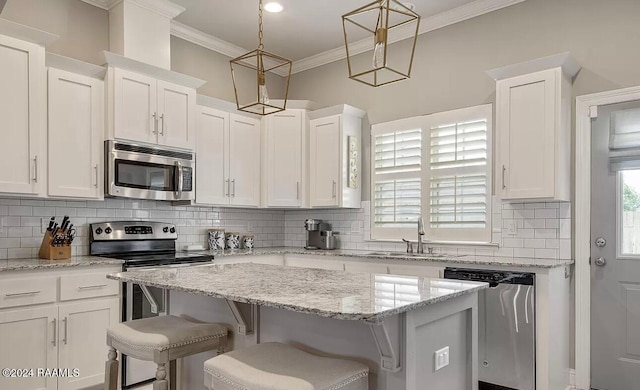 kitchen with white cabinets, decorative light fixtures, a center island, and stainless steel appliances