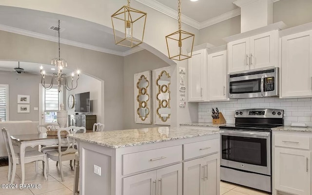 kitchen featuring white cabinets, decorative light fixtures, a center island, and stainless steel appliances