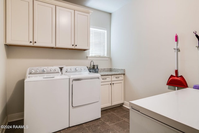 clothes washing area with cabinets and separate washer and dryer