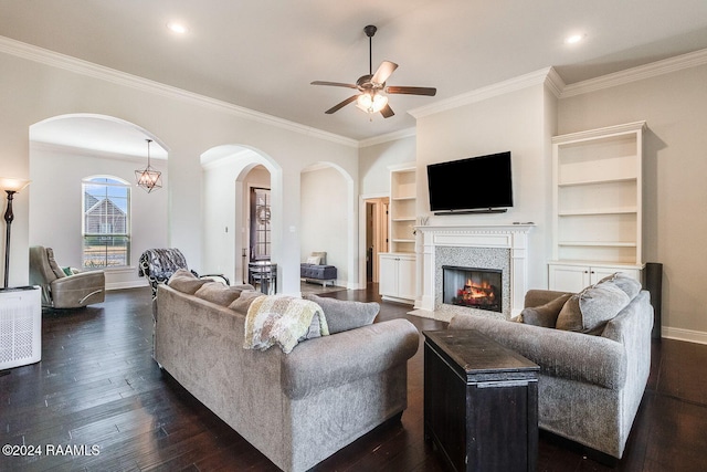 living room with ceiling fan with notable chandelier, dark hardwood / wood-style floors, built in features, and ornamental molding