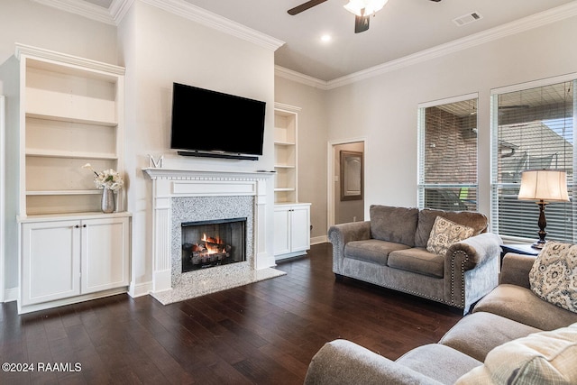 living room featuring built in shelves, crown molding, and dark hardwood / wood-style flooring