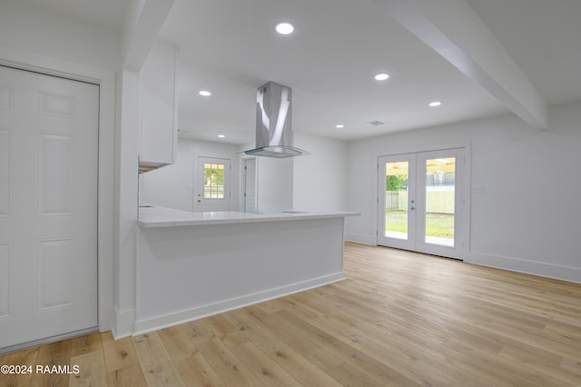 kitchen with french doors, beamed ceiling, ventilation hood, kitchen peninsula, and white cabinets