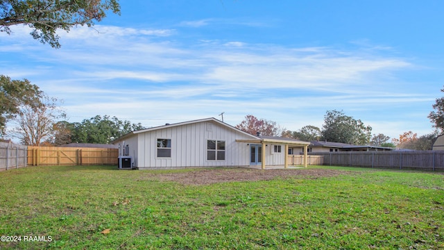 back of house featuring a yard and central AC