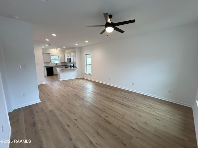 unfurnished living room featuring a ceiling fan, recessed lighting, wood finished floors, and baseboards