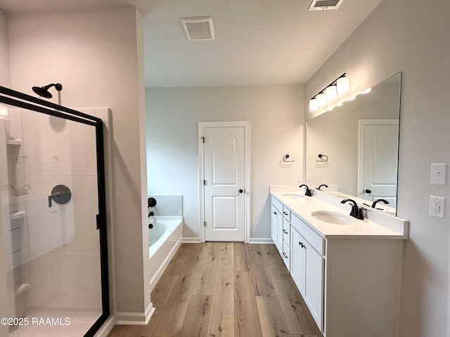304 Weaver Way, Maurice, LA 70555 - full bath with wood finished floors, double vanity, a stall shower, a garden tub, and baseboards