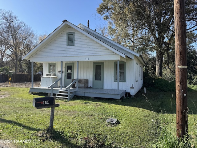 view of front of house with covered porch and a front lawn