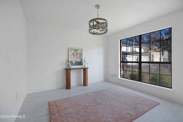 interior space featuring light wood-type flooring and a notable chandelier