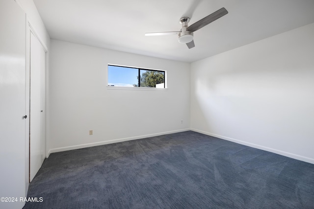 carpeted spare room with ceiling fan