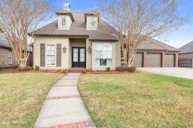 view of front facade featuring a front lawn, a garage, and french doors