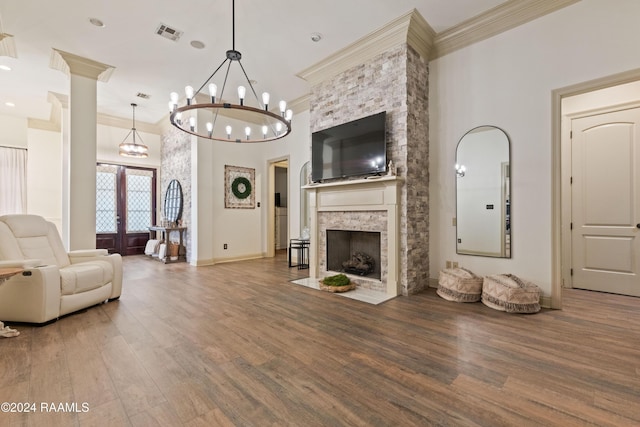 living room featuring hardwood / wood-style flooring, crown molding, a fireplace, and french doors