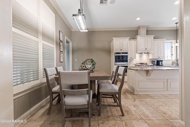 tiled dining area featuring crown molding